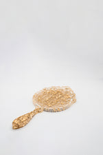 small handheld gold flake mirror